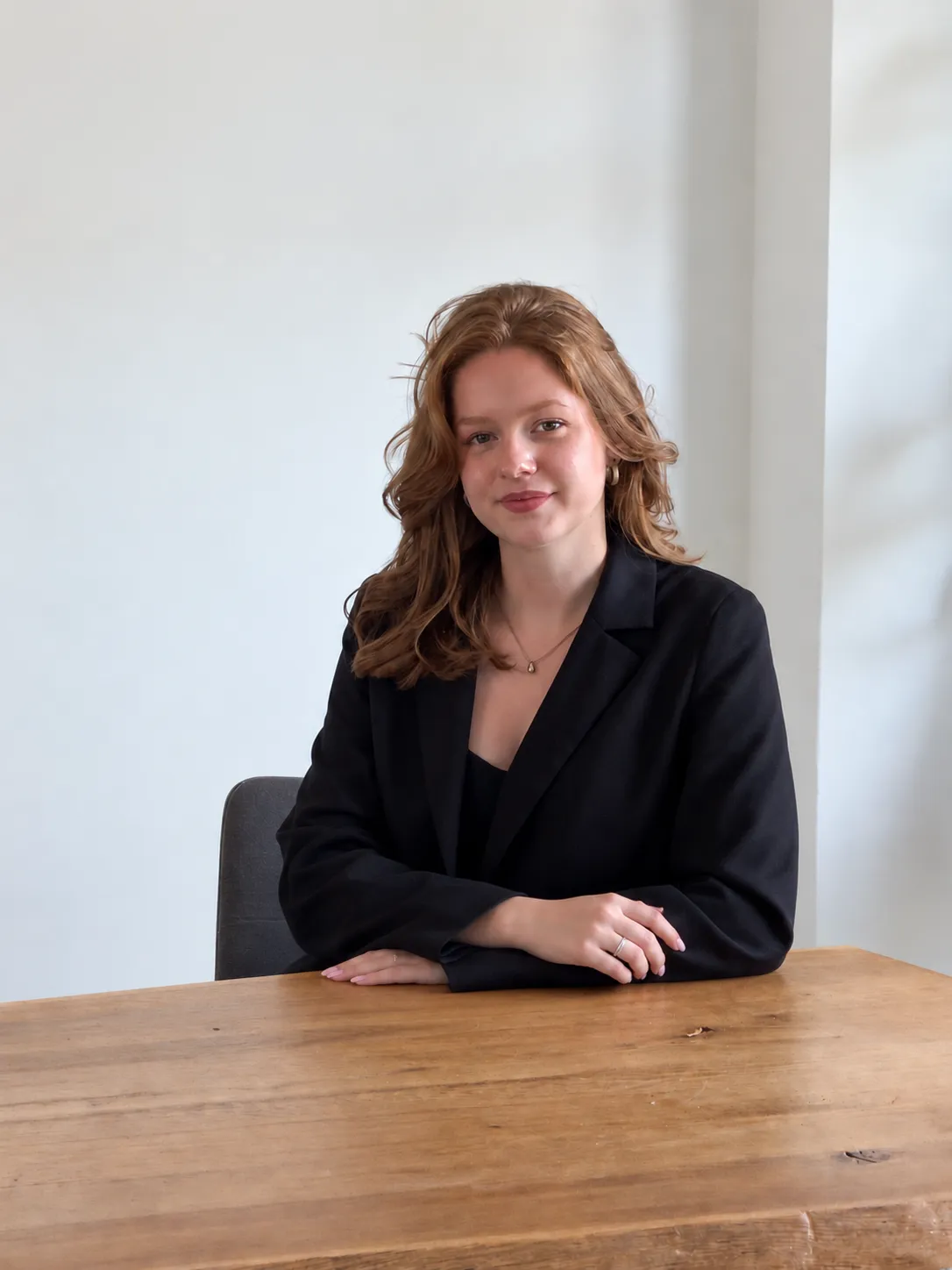 Esmee Selier, grafisch vormgever, lachend voor een lichte achtergrond